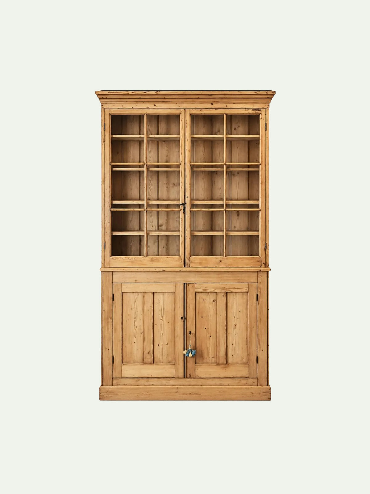 A tall wooden hutch cabinet with a natural pine finish, featuring a glass-front upper section with two doors and a lower section with two paneled doors, shown against a plain light background.