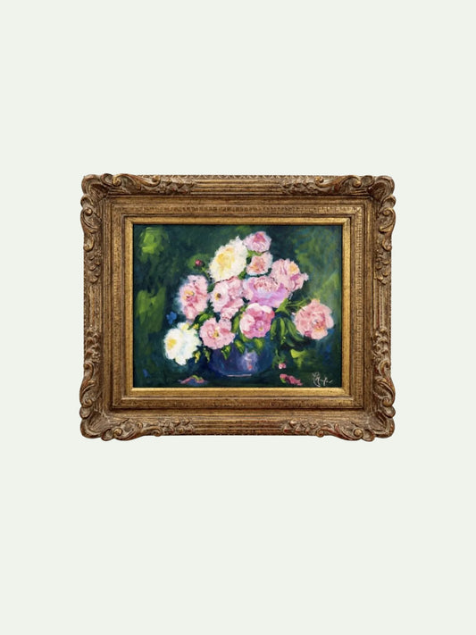 An ornate gold-framed painting depicting a bouquet of pink and white flowers in a dark green and blue vase, set against a light off-white background.