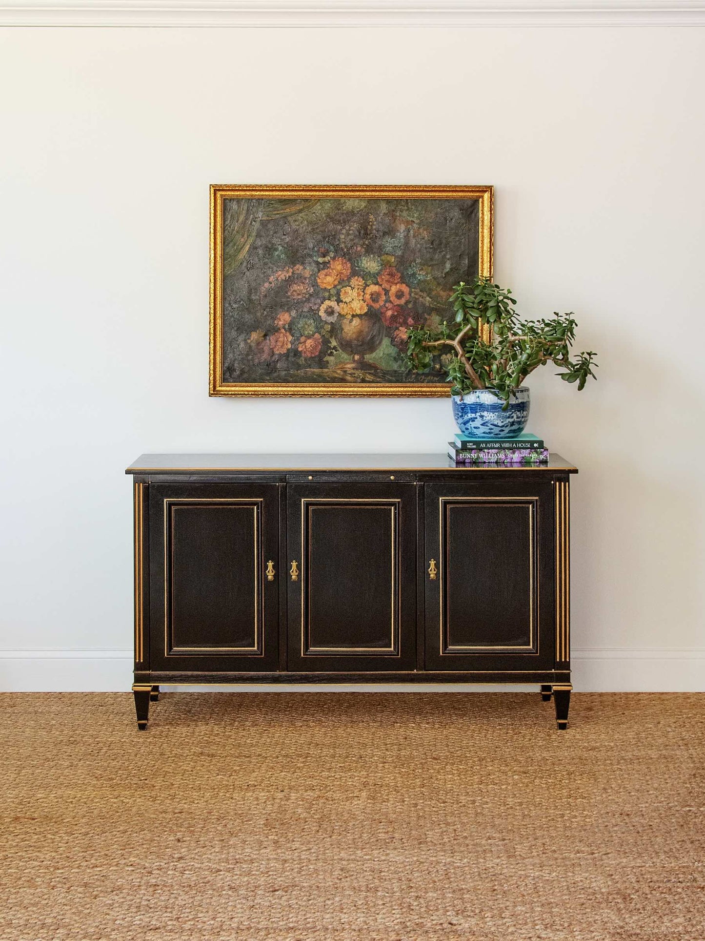 Black cabinet with decorative items against a white wall
