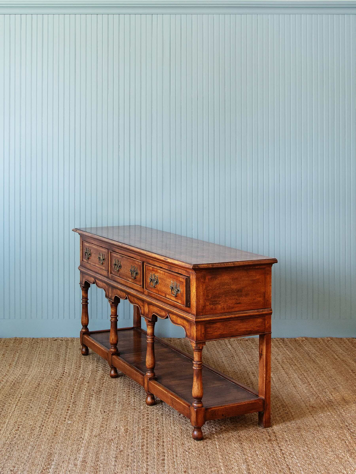 side profile of wooden dresser with three drawers