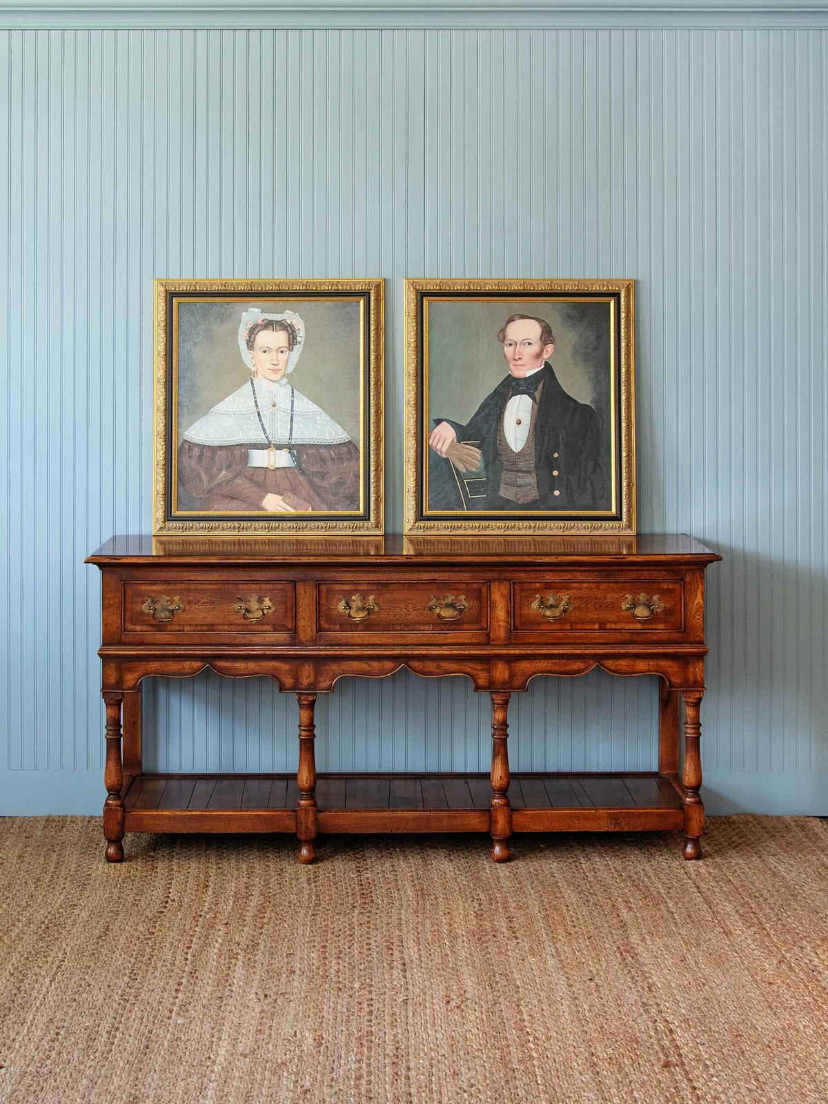 antique dresser with three draws and two antique paintings on top